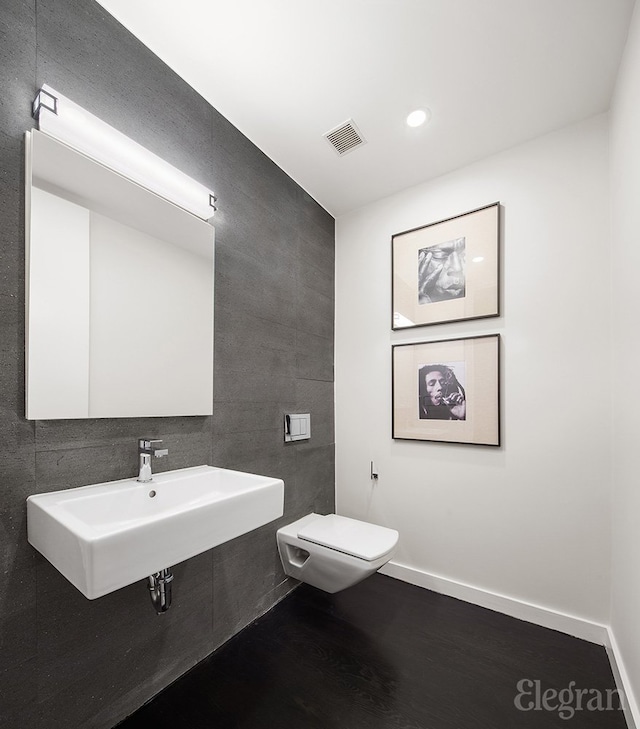 1 York St Unit 4-F, New York City, NY 10013 - half bath featuring a sink, toilet, tile walls, wood finished floors, and visible vents