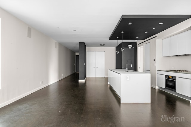 kitchen featuring modern cabinets, an island with sink, a sink, white cabinetry, and stainless steel appliances