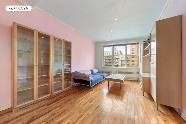 sitting room featuring visible vents, radiator, and light wood-style floors