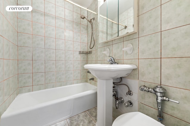 full bath with tile patterned floors, toilet, tile walls, and shower / bathtub combination