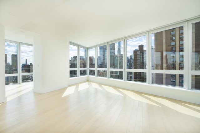 unfurnished sunroom with a city view and wood finished floors
