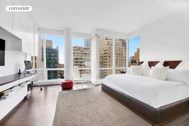 bedroom with a city view, dark wood-type flooring, and visible vents