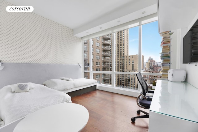 office space featuring wood finished floors, an accent wall, and wallpapered walls