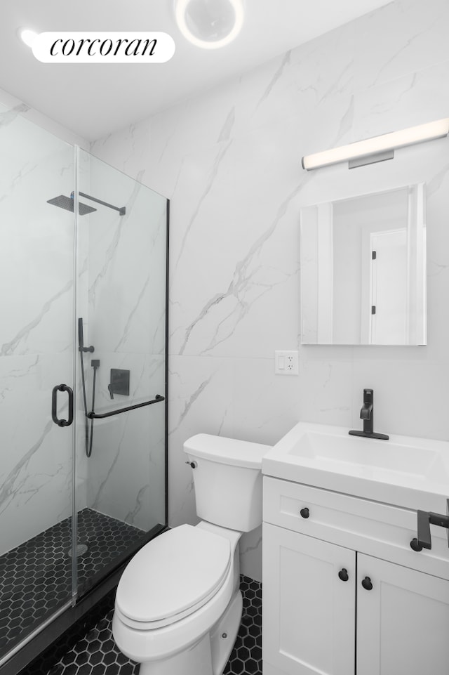 bathroom with a marble finish shower, tile walls, toilet, and vanity