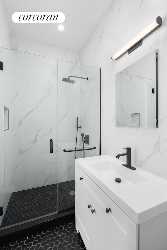 bathroom featuring a marble finish shower, vanity, and recessed lighting