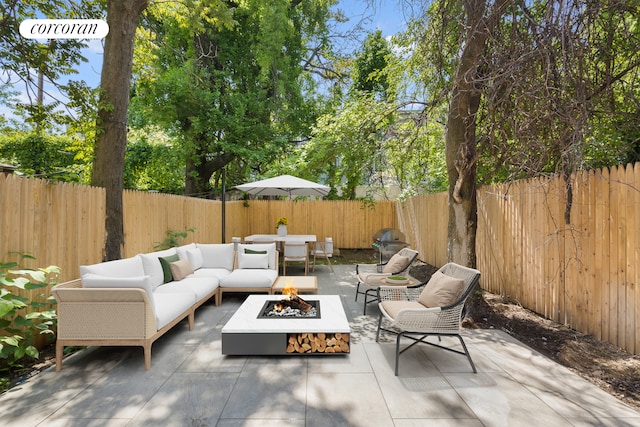 view of patio with a fenced backyard and an outdoor living space with a fire pit