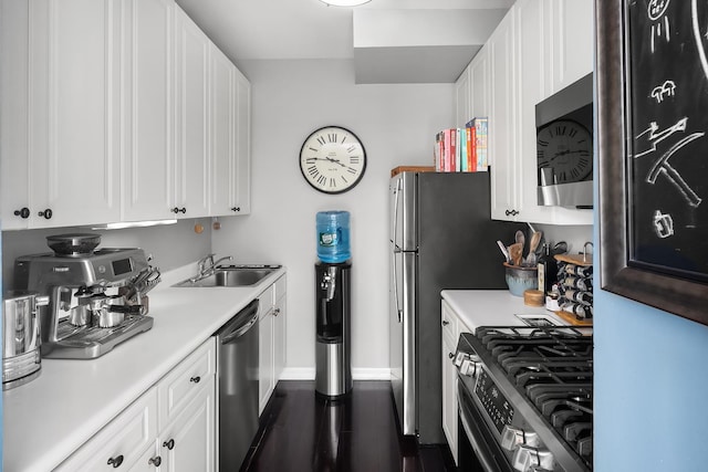 kitchen with a sink, appliances with stainless steel finishes, white cabinets, and light countertops