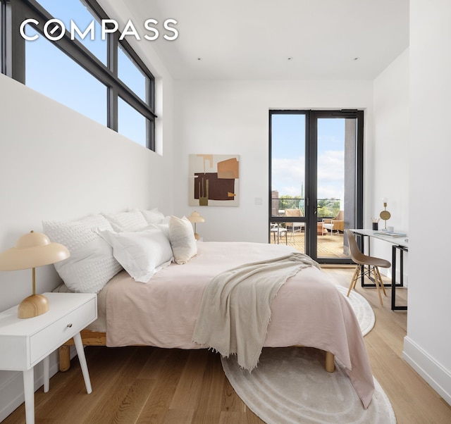 bedroom featuring light wood finished floors, multiple windows, and access to outside