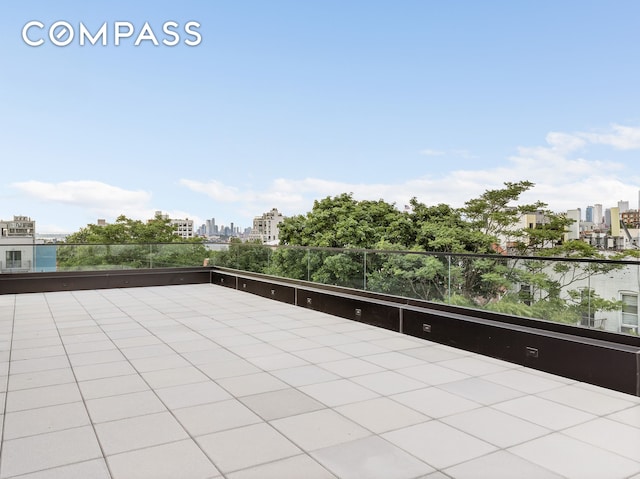 view of patio / terrace with a view of city and a balcony