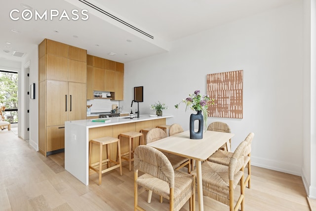 dining space with visible vents, baseboards, and light wood-style flooring