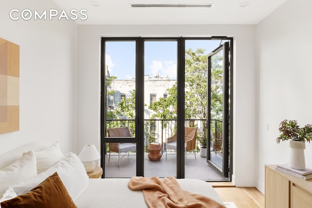 bedroom featuring visible vents, light wood finished floors, and access to outside