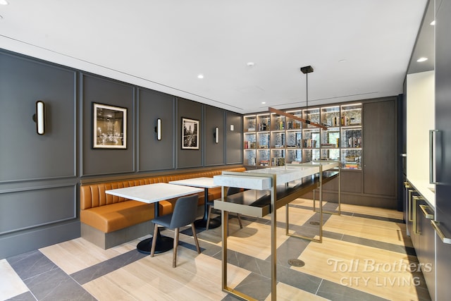 bar featuring recessed lighting, indoor wet bar, hanging light fixtures, and a decorative wall