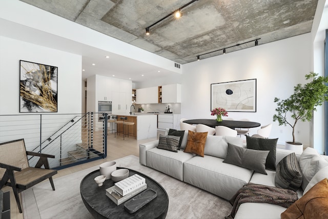living area with visible vents, track lighting, and light wood finished floors