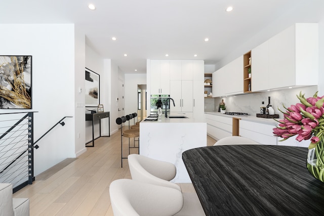 kitchen with open shelves, modern cabinets, white cabinets, and a sink