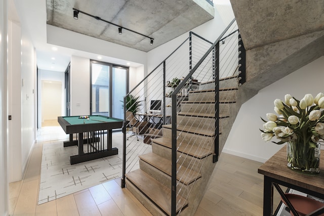stairs featuring pool table, baseboards, and wood finished floors