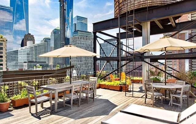 wooden deck with a city view, outdoor dining space, and stairs