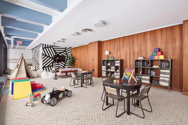 dining space with visible vents and wood walls