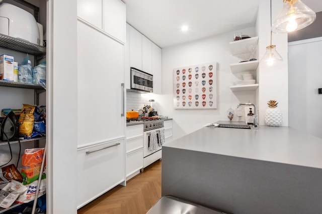 kitchen featuring stainless steel microwave, open shelves, white gas range, decorative backsplash, and a sink