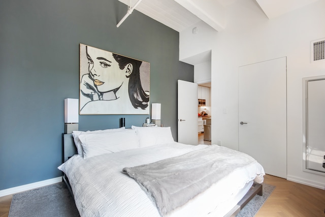 bedroom with visible vents, baseboards, and a towering ceiling