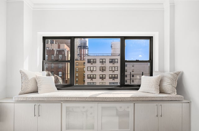 sitting room with a bar and crown molding