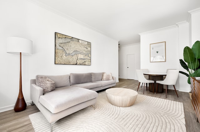 living area with light wood-type flooring, baseboards, and ornamental molding