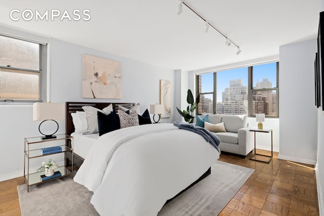 bedroom featuring a view of city and rail lighting