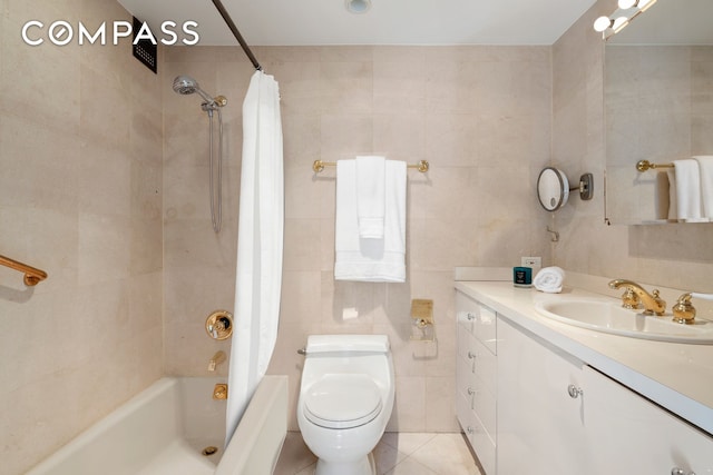 bathroom with vanity, tile patterned flooring, shower / bath combination with curtain, tile walls, and toilet