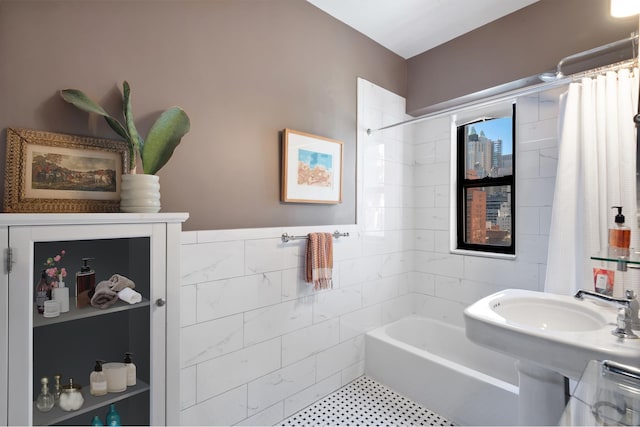 full bath with wainscoting, tile walls, and shower / tub combo