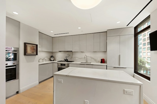 kitchen with tasteful backsplash, gray cabinetry, modern cabinets, and a sink