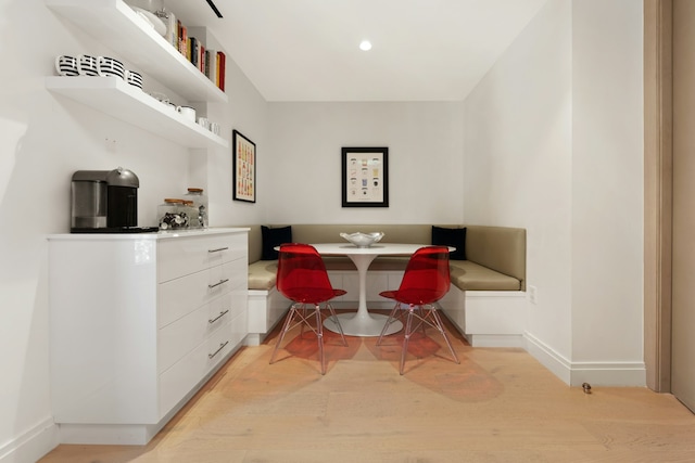 dining room with baseboards and light wood finished floors