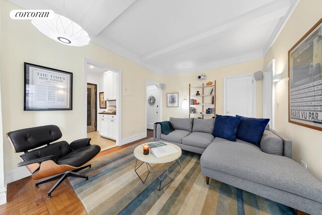 living room featuring beam ceiling, radiator, and visible vents