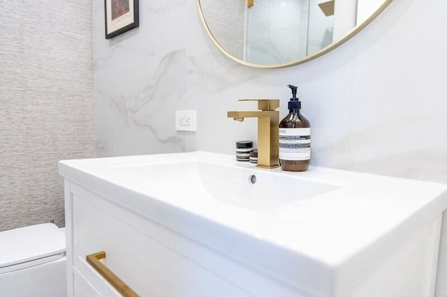 half bath featuring toilet, tile walls, and vanity