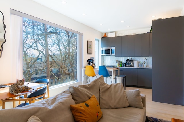 living room with light wood-style flooring and recessed lighting