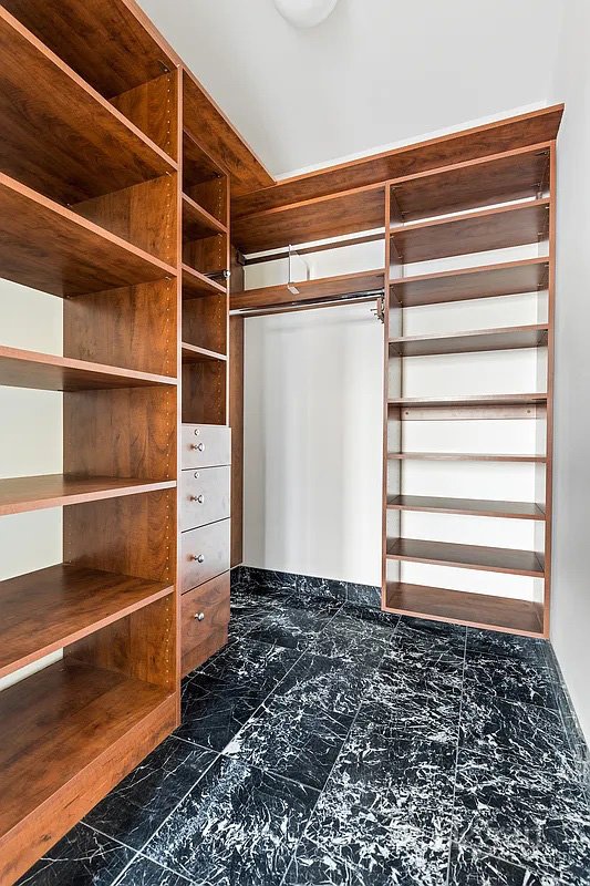 walk in closet with marble finish floor