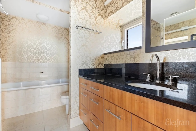 full bathroom featuring tiled bath, tile patterned flooring, wallpapered walls, and vanity