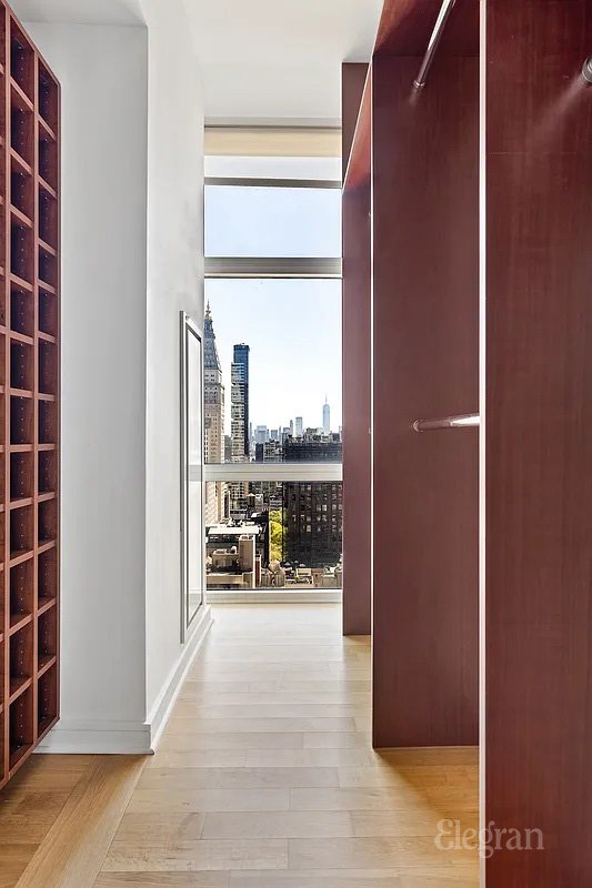 interior space with a city view, floor to ceiling windows, baseboards, and wood finished floors