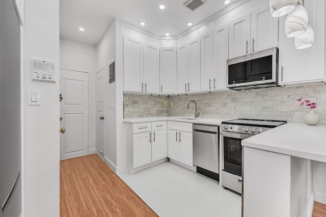 kitchen featuring visible vents, appliances with stainless steel finishes, white cabinets, and light countertops