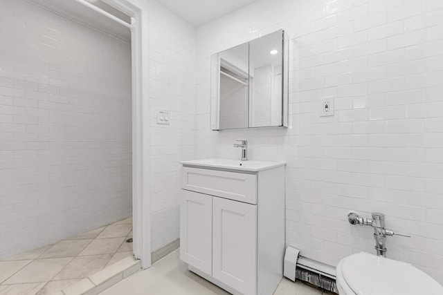 bathroom with vanity, tile walls, toilet, and a baseboard radiator