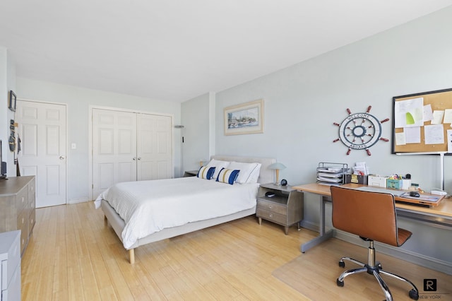 bedroom with light wood finished floors and a closet