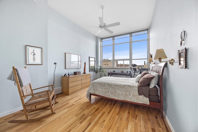 bedroom featuring ceiling fan, baseboards, and light wood-style floors