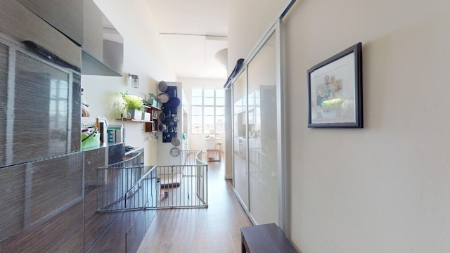 hallway with wood finished floors and an upstairs landing