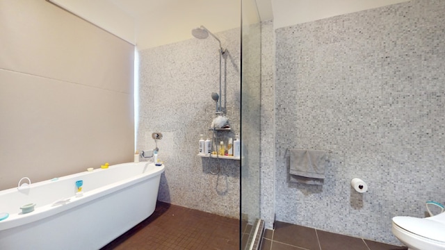 full bathroom featuring a soaking tub, tile patterned flooring, walk in shower, tile walls, and toilet