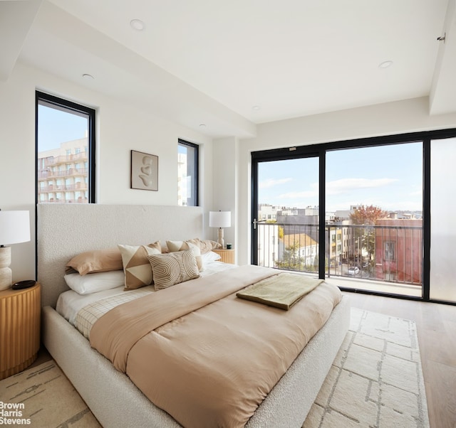 bedroom with wood finished floors and access to outside