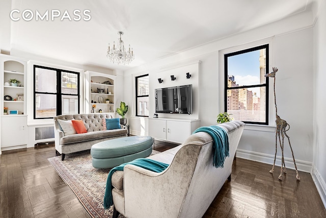 living room featuring baseboards, a notable chandelier, and radiator heating unit