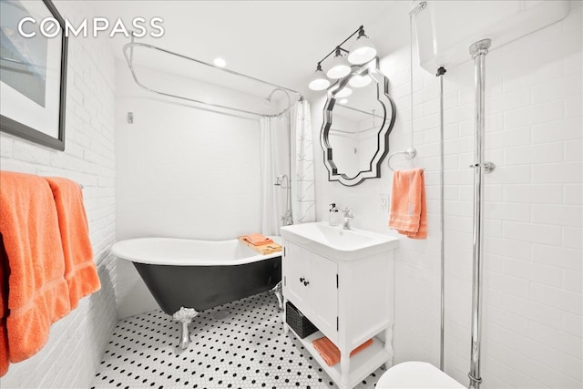 bathroom featuring a tile shower, tile walls, tile patterned flooring, a freestanding bath, and vanity