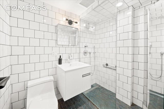 577 Madison St Unit 1B, New York City, NY 11221 - bathroom with vanity, toilet, a walk in shower, and tile walls