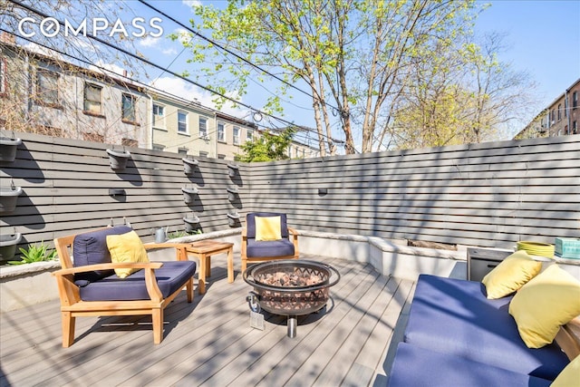 wooden terrace with an outdoor fire pit and fence