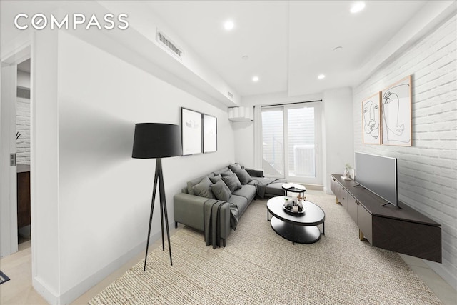 living room with visible vents, recessed lighting, brick wall, and baseboards