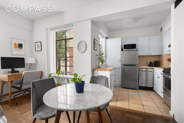 kitchen with white cabinetry, light countertops, tasteful backsplash, and stainless steel appliances