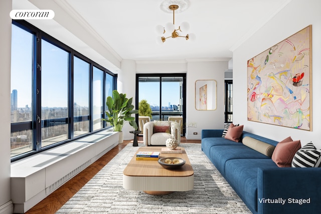 living area with an inviting chandelier, a view of city, baseboards, and ornamental molding